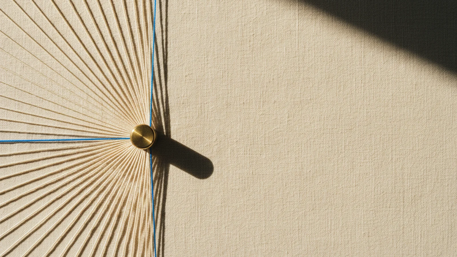 Fotografía cenital de cables de cobre convergiendo en un nodo de latón brillante sobre lino crema.